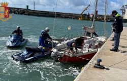 Ostia, barca a vela in difficoltà rischia il naufragio sulla scogliera del porto, sciagura evitata dalle moto d'acqua della polizia