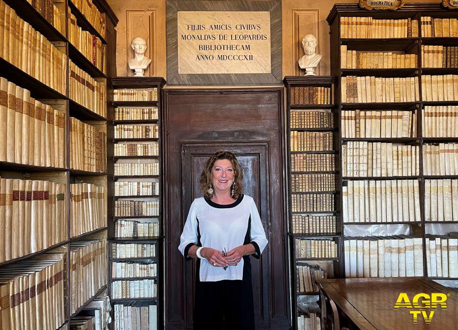 Olimpia Leopardi nella Biblioteca di famiglia in alto l'epigrafe con la quale Monaldo apre la biblioteca ai suoiconcittadini