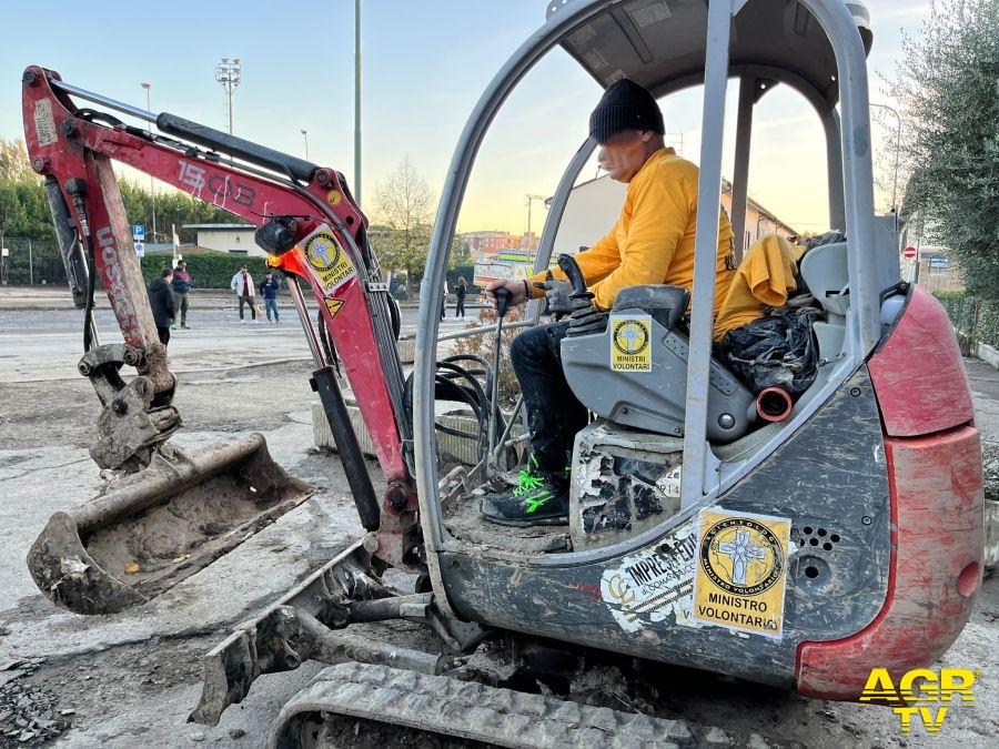 Ministri volontari con escavatore alluvione Toscana Campi Bisenzio