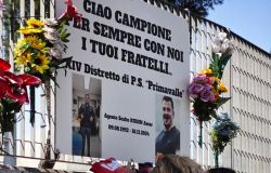 La madre depone un mazzo di fiori sulla targa che ricorda Amar Kudin